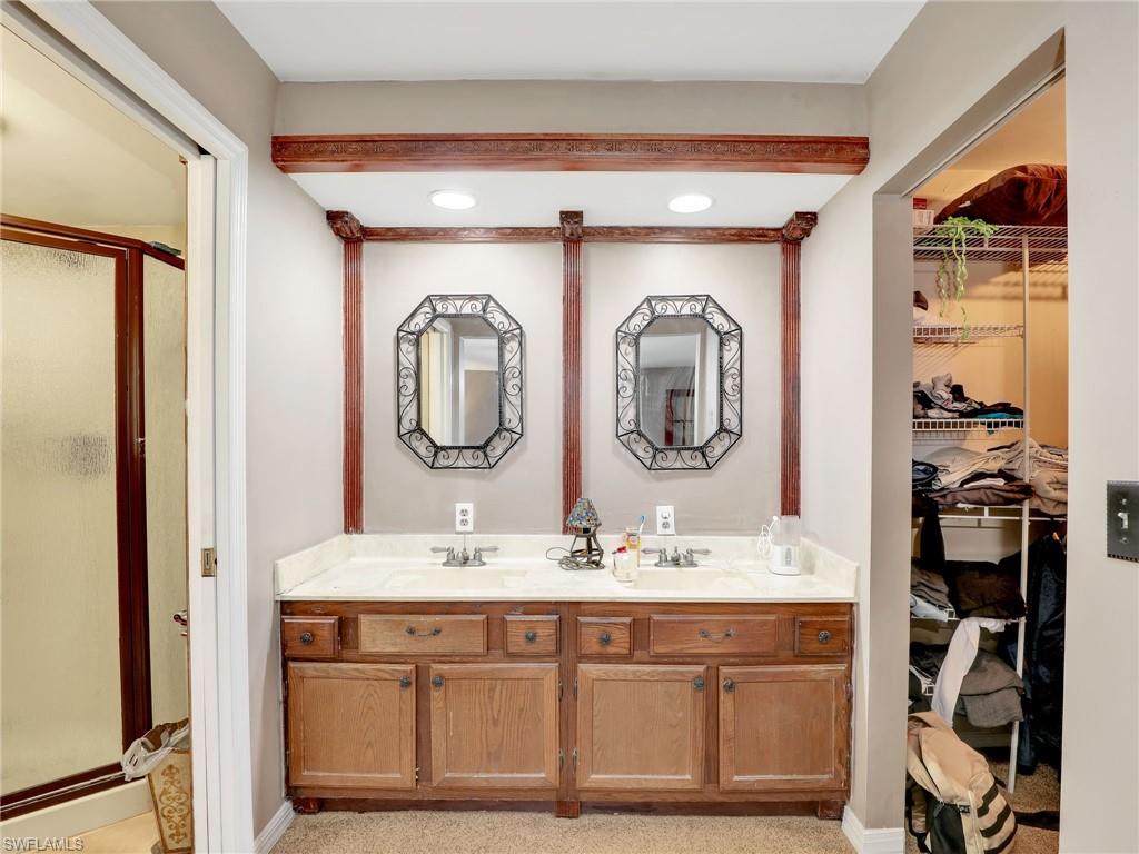 210 25th Street Southwest Naples, FL 34117 - Photo 18 of 33 Bathroom featuring double vanity, a stall shower, and a spacious closet