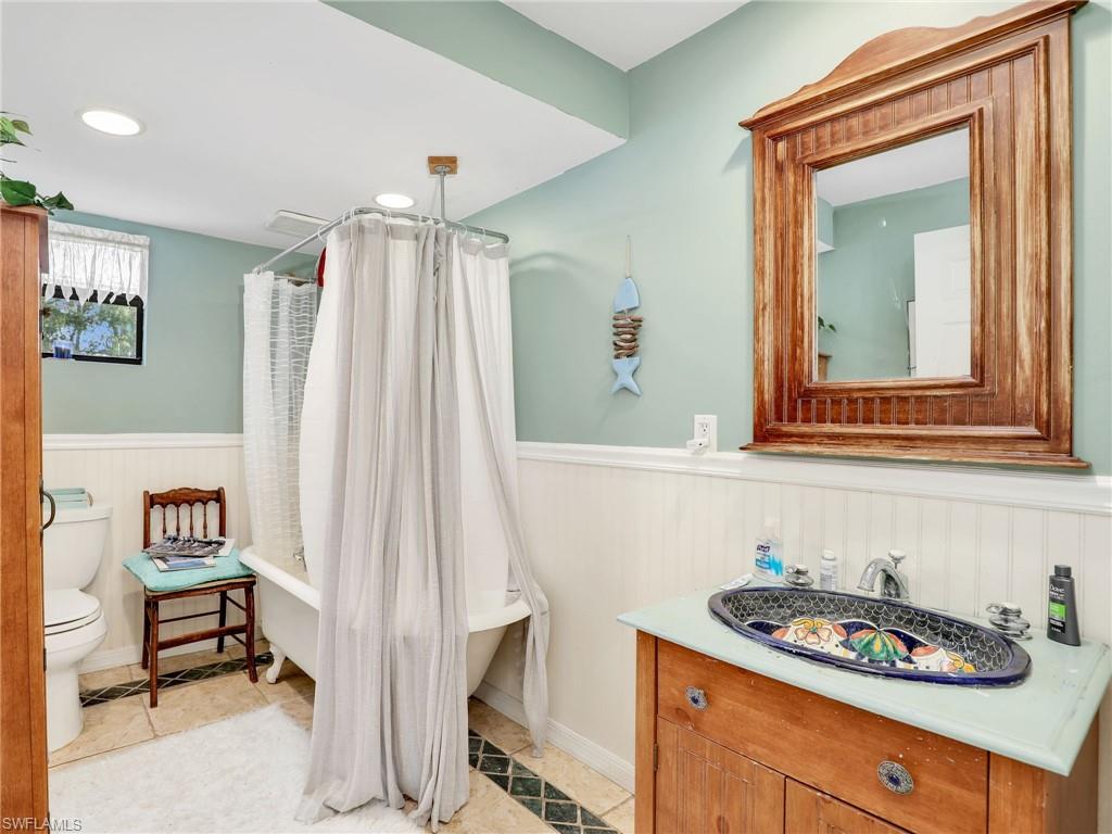 210 25th Street Southwest Naples, FL 34117 - Photo 22 of 33 Full bathroom featuring vanity, a wainscoted wall, a combined bath / shower with freestanding tub, recessed lighting, and light tile patterned flooring