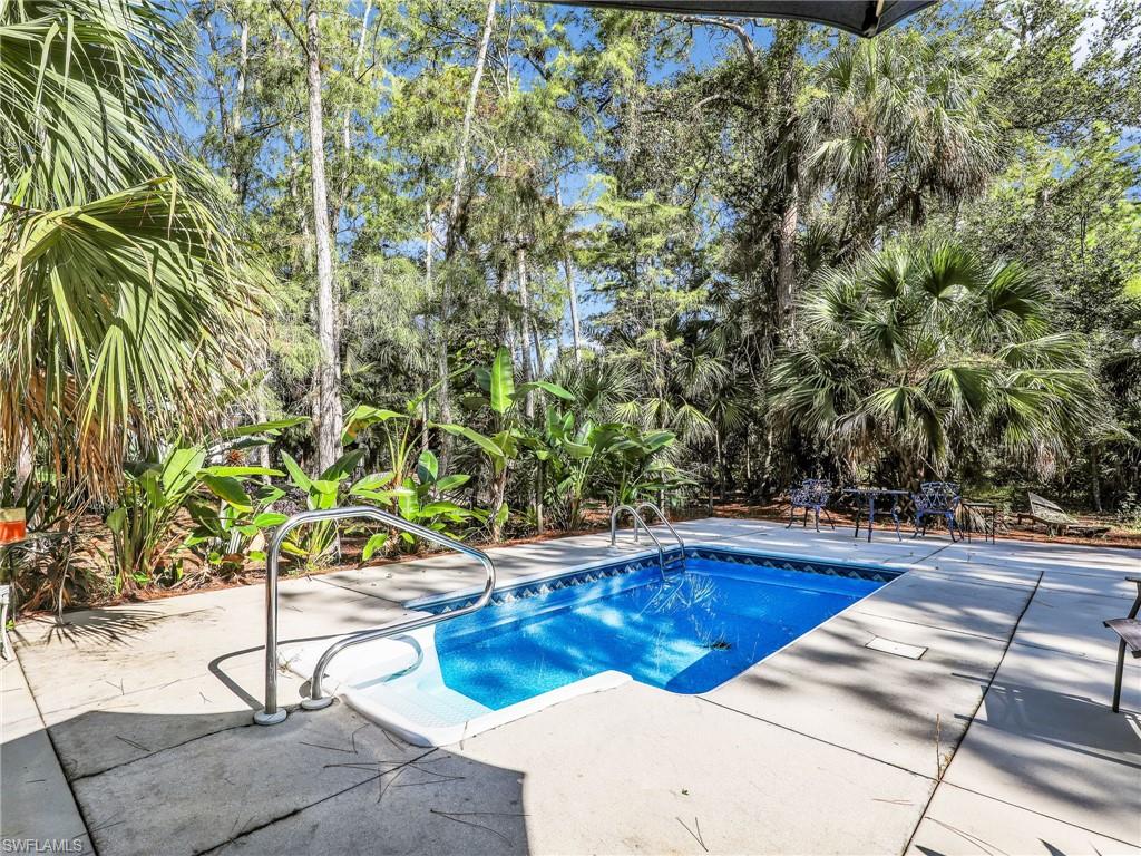 210 25th Street Southwest Naples, FL 34117 - Photo 27 of 33 Swimming pool featuring a patio area and view of scattered trees