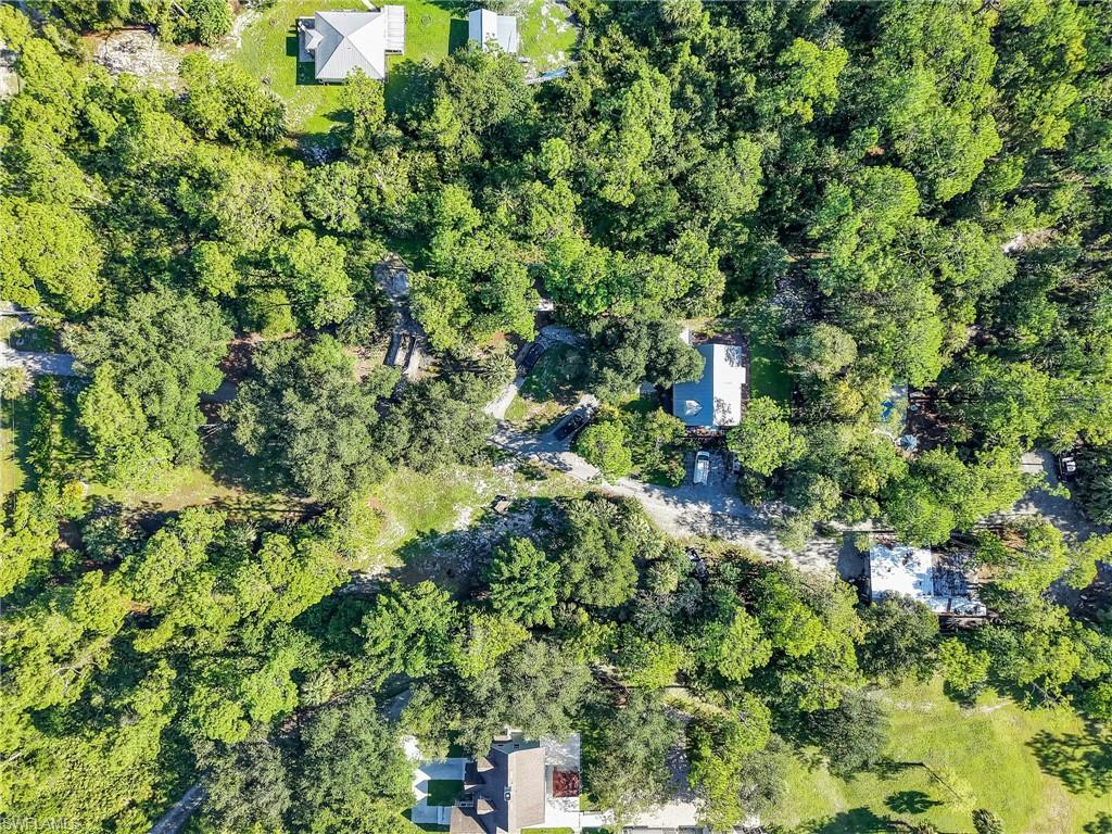 210 25th Street Southwest Naples, FL 34117 - Photo 31 of 33 Aerial view of property's location featuring a heavily wooded area
