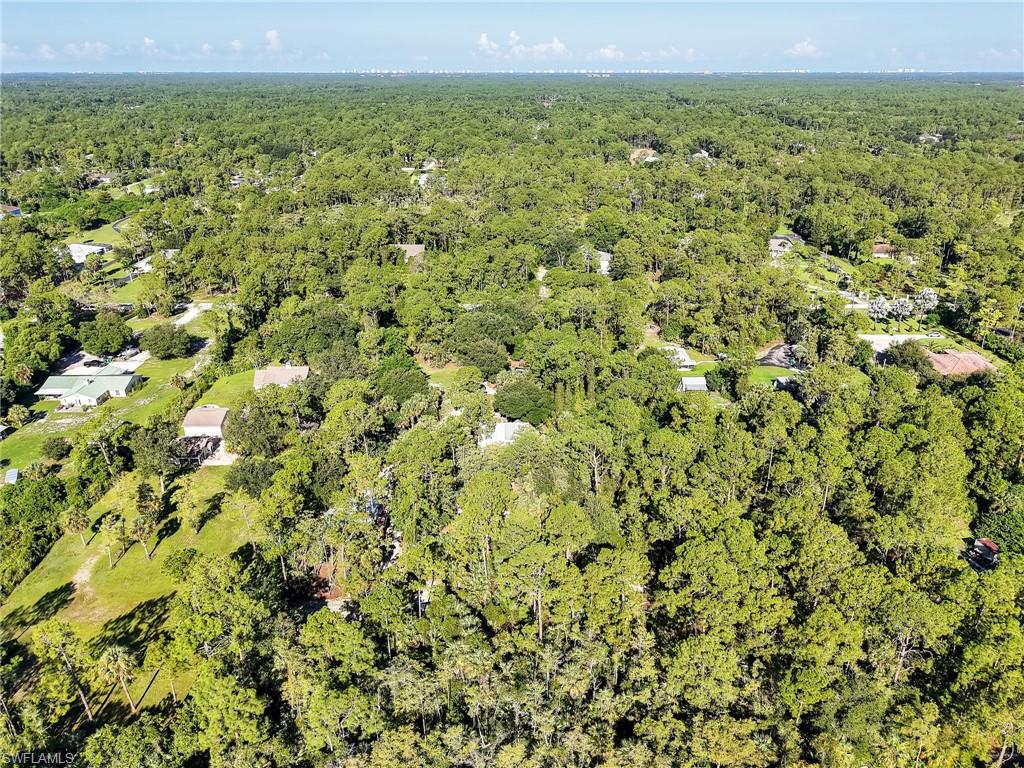 210 25th Street Southwest Naples, FL 34117 - Photo 33 of 33 Aerial view of property and surrounding area with a forest