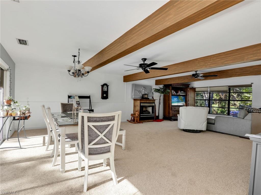 210 25th Street Southwest Naples, FL 34117 - Photo 10 of 33 Dining room with beamed ceiling, light carpet, a ceiling fan, and a chandelier