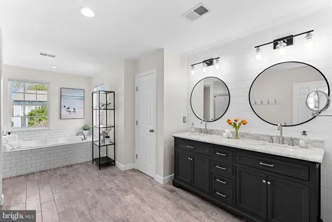 a bathroom with a sink mirror vanity and a bathtub