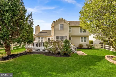 a view of a house with a big yard and large trees