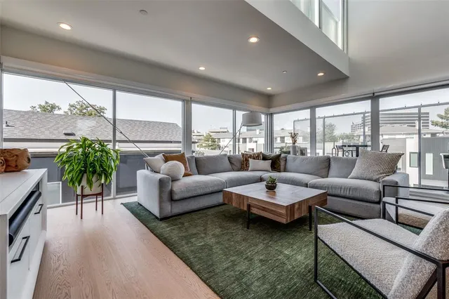 a living room with furniture potted plant and a large window