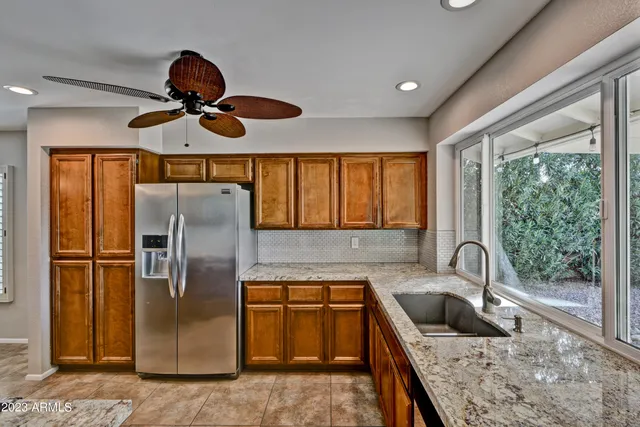 a kitchen with stainless steel appliances granite countertop a refrigerator a sink and a stove