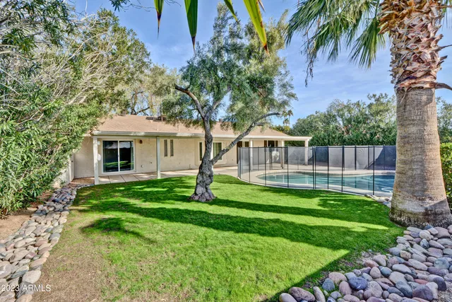 a view of a house with backyard and a tree