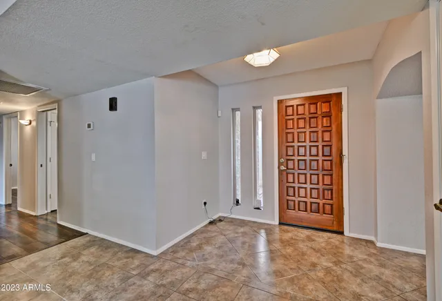an empty room with windows cabinet and front door
