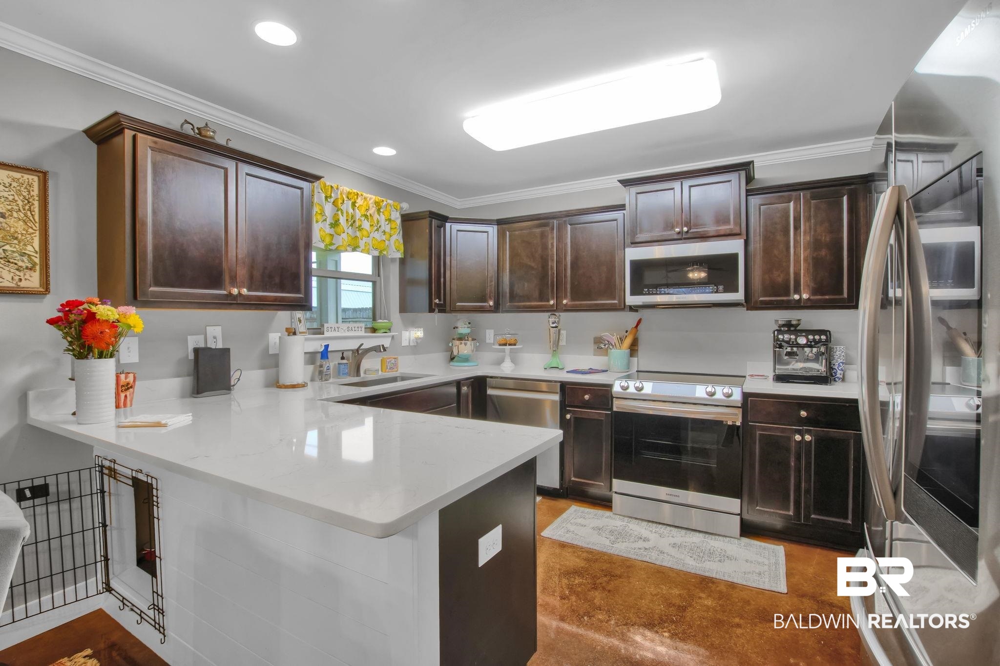 203 Lakefront Circle Summerdale, AL 36580 - Photo 22 of 69 Kitchen with dark brown cabinets, sink, kitchen peninsula, appliances with stainless steel finishes, and crown molding