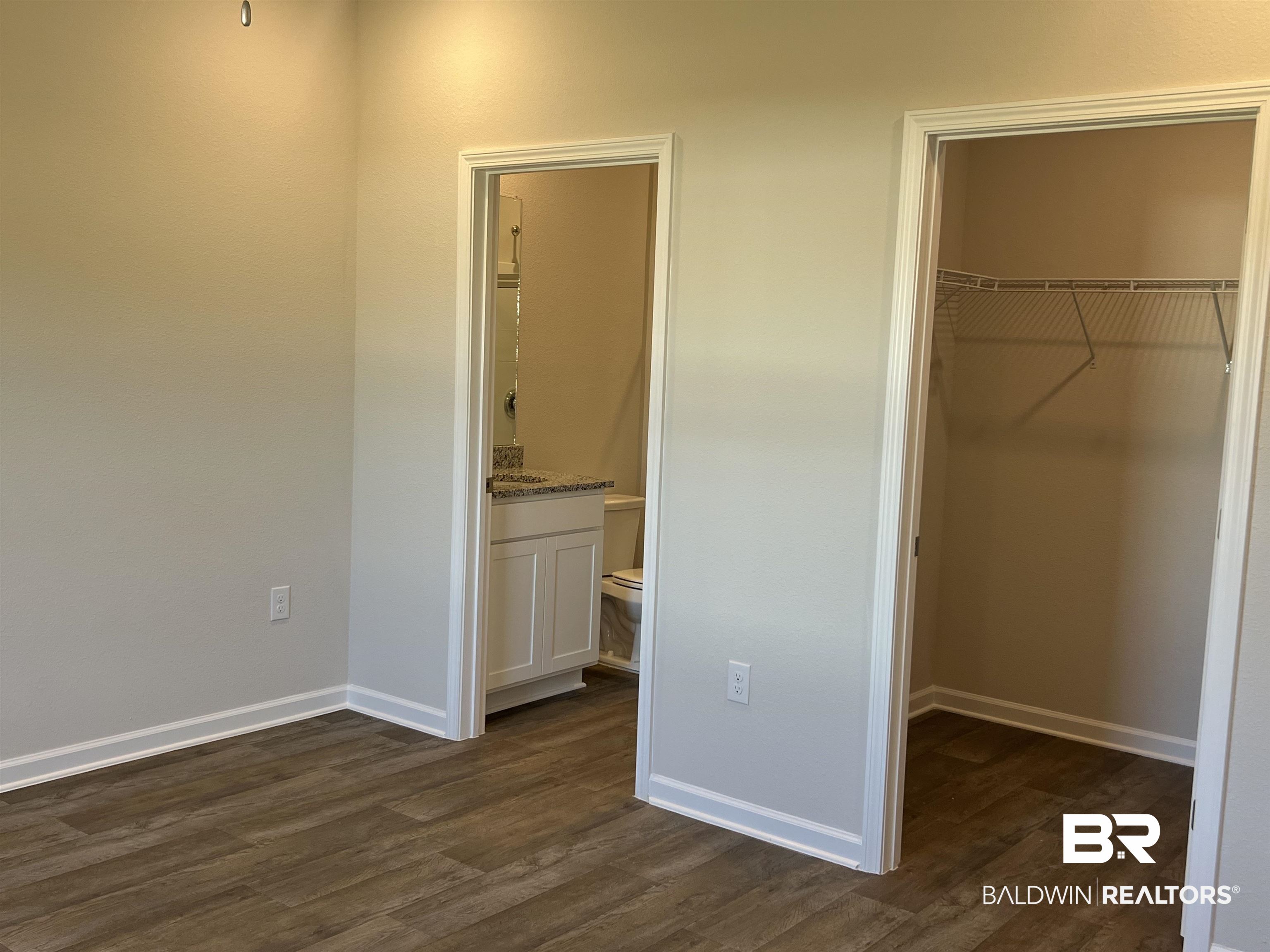 12829 Patriot Way Daphne, AL 36527 - Photo 23 of 38 Unfurnished bedroom featuring ensuite bath, dark hardwood / wood-style floors, a walk in closet, and a closet