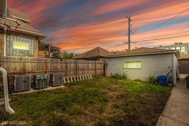 a view of a house with a small yard and wooden fence