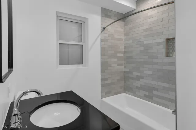 a bathroom with a granite countertop sink toilet and bathtub