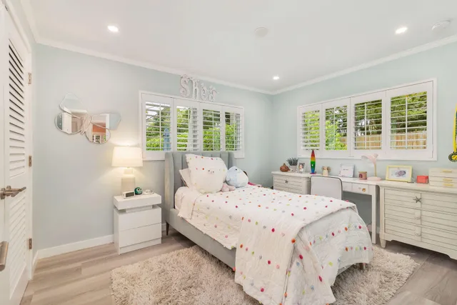 a bedroom with a bed and a large window