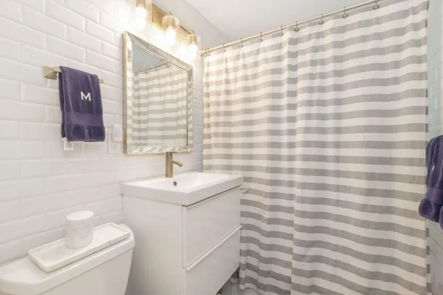 a bathroom with a sink a toilet and shower curtain