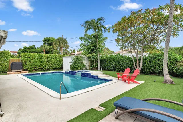 a view of a backyard with swimming pool and sitting space