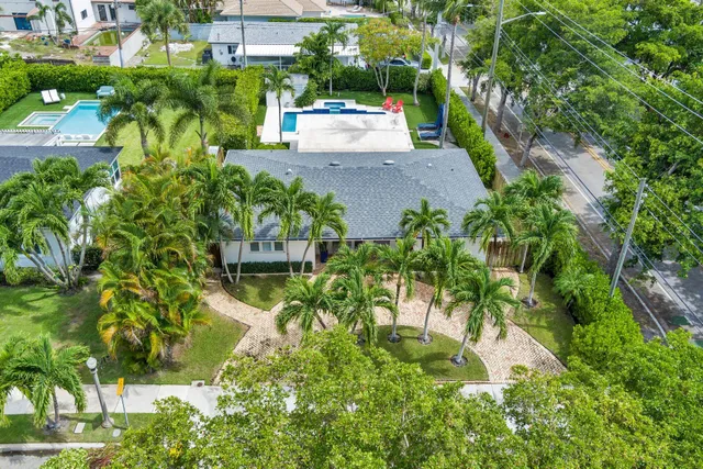 an aerial view of a house with a yard and large trees