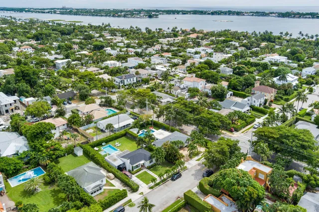 an aerial view of residential houses with outdoor space and trees