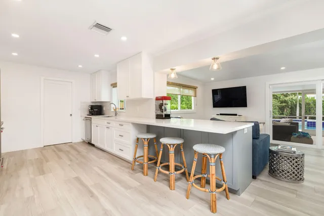a kitchen with a sink stainless steel appliances and white cabinets