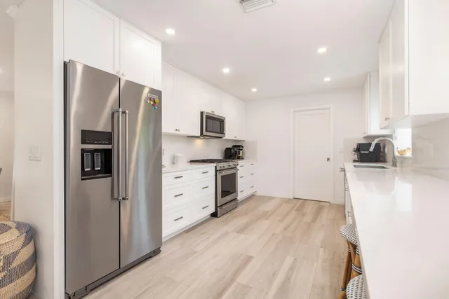 a kitchen with stainless steel appliances a refrigerator stove microwave and cabinets