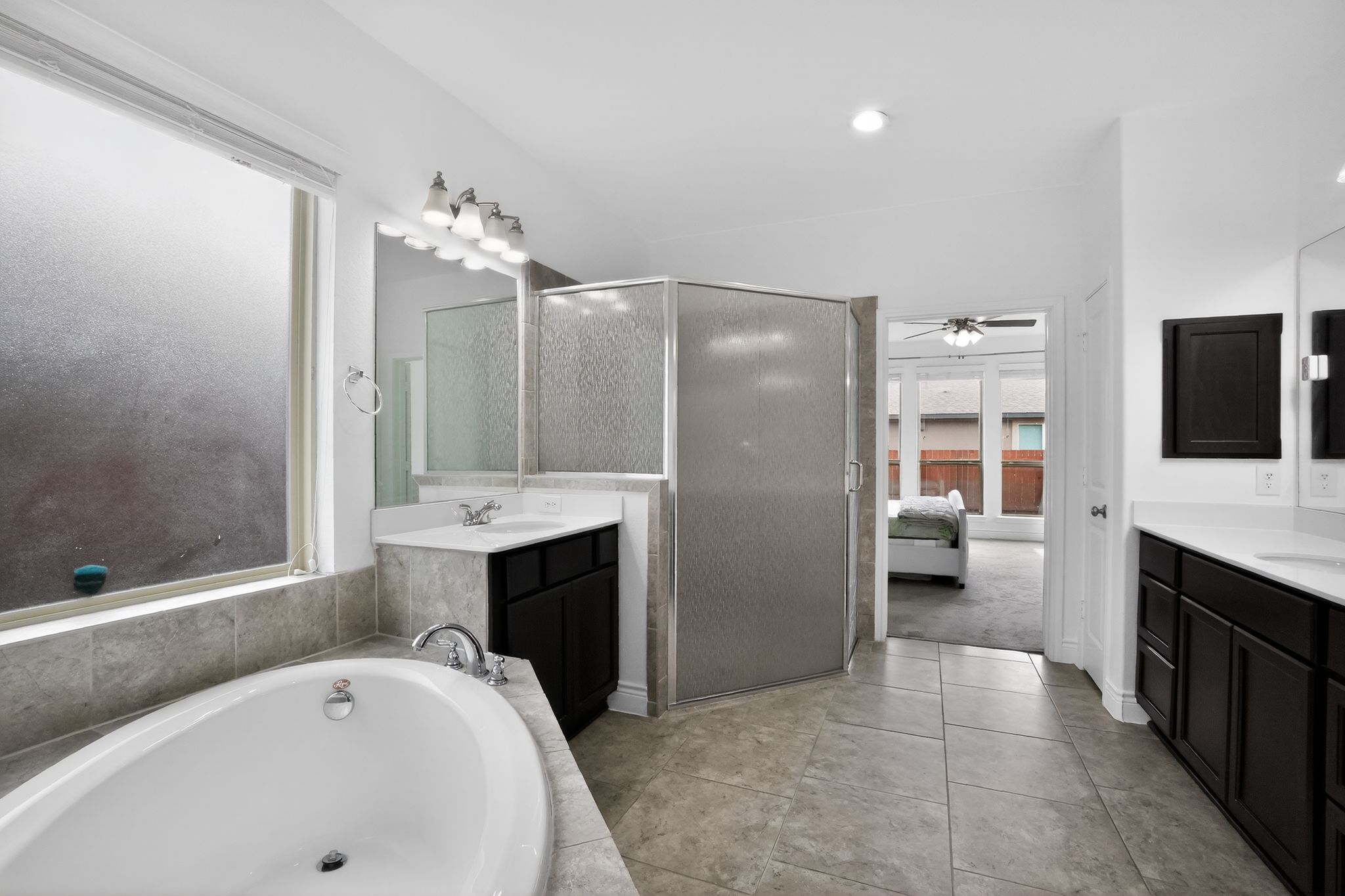 400 Cortona Lane Georgetown, TX 78628 - Photo 21 of 40 Ensuite bathroom featuring a garden tub, two vanities, ceiling fan, and light tile patterned floors