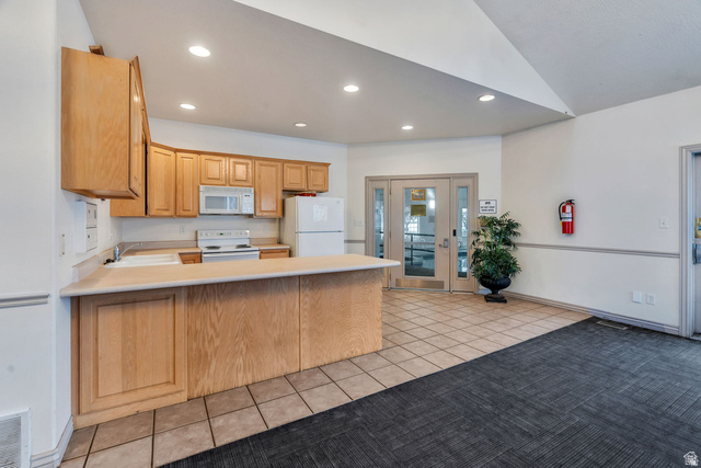 986 Independence Avenue Provo, UT 84604 - Photo 22 of 29 Functional kitchen area with wood-finish cabinetry, white appliances, and a light-toned countertop