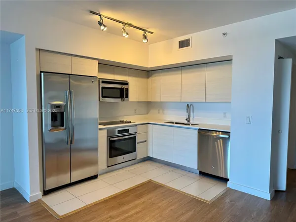 a kitchen with stainless steel appliances granite countertop a refrigerator and a stove top oven