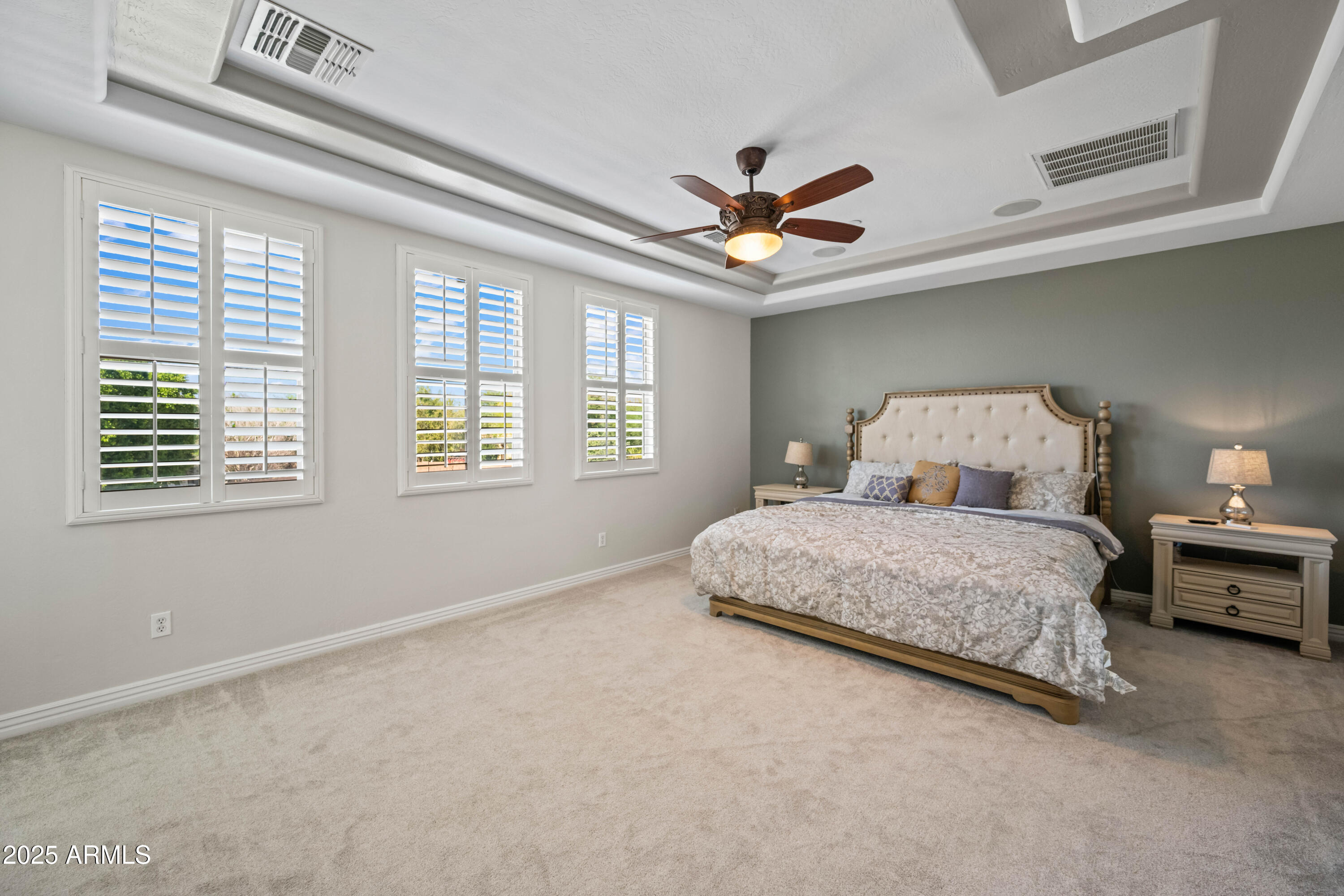 16880 West Jackson Street Goodyear, AZ 85338 - Photo 48 of 86 a bedroom with a large bed chandelier and a window
