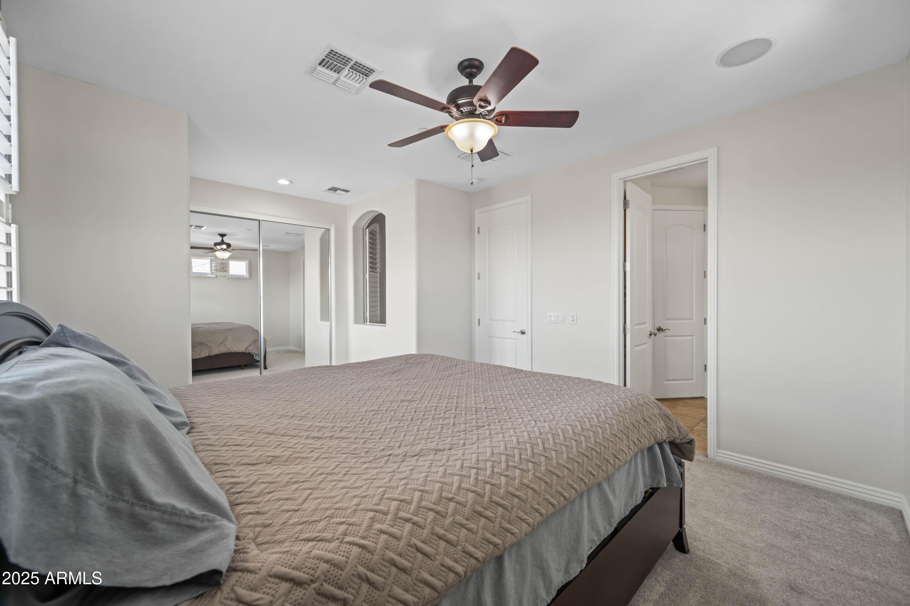 16880 West Jackson Street Goodyear, AZ 85338 - Photo 57 of 86 a bedroom with a large bed and a ceiling fan