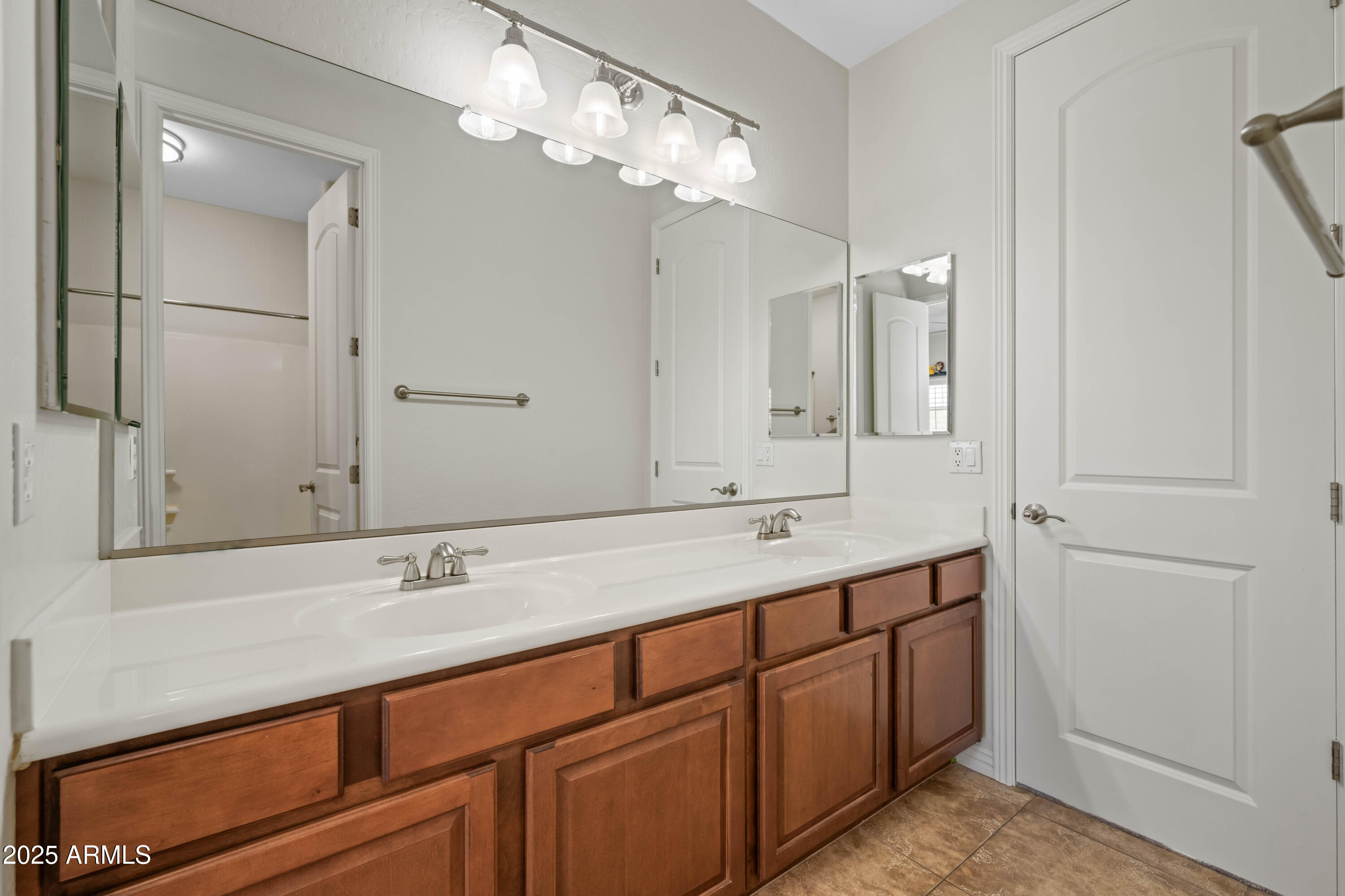 16880 West Jackson Street Goodyear, AZ 85338 - Photo 64 of 86 a bathroom with a double vanity sink and a mirror