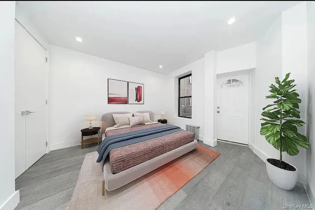 a bedroom with a bed and a potted plant