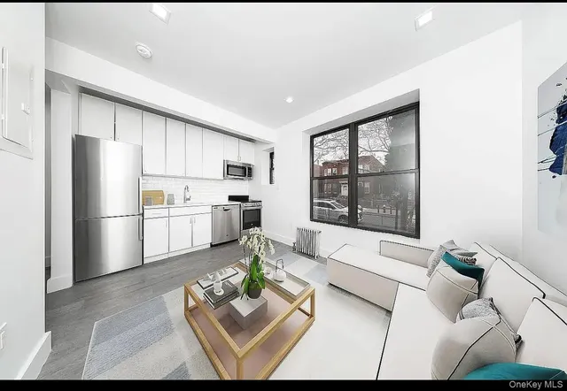 a living room with furniture wooden floor and a refrigerator