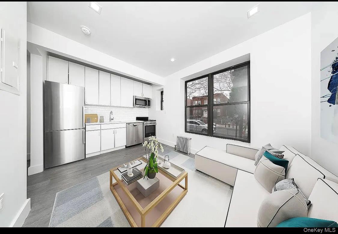 372 Rutland Road Brooklyn, NY 11225 - Photo 7 of 10 Living area with radiator heating unit, light wood-type flooring, and electric panel