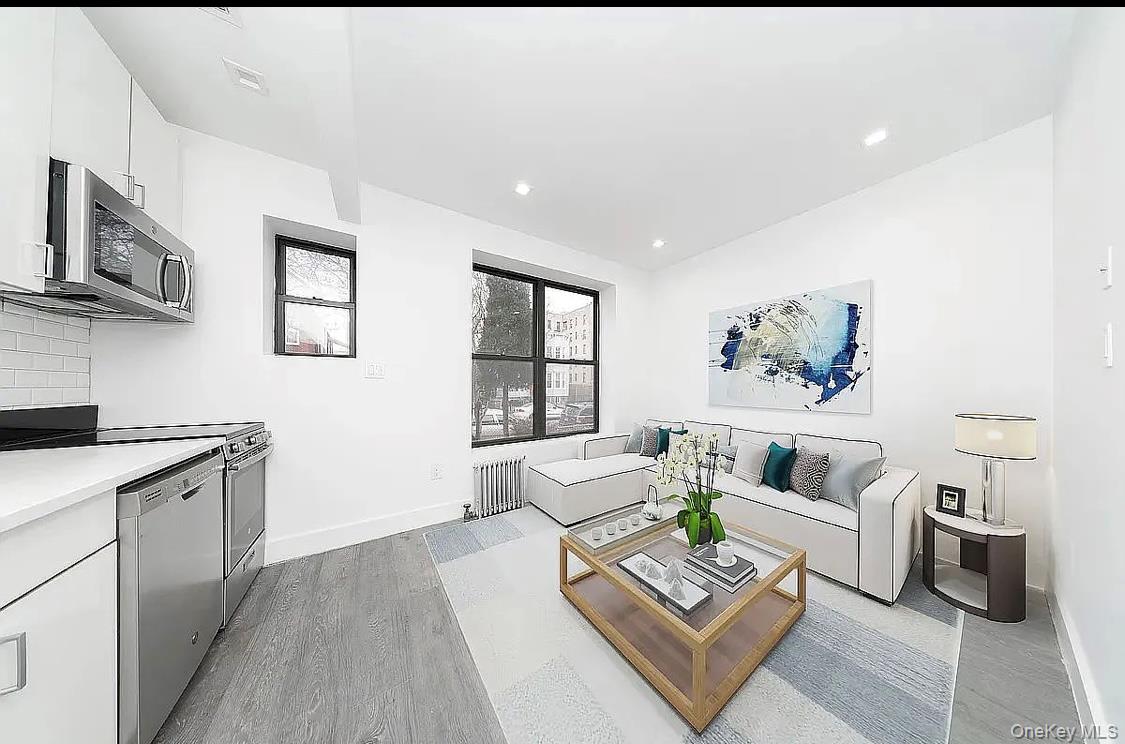 372 Rutland Road Brooklyn, NY 11225 - Photo 9 of 10 Living room featuring radiator heating unit, light wood-type flooring, and recessed lighting
