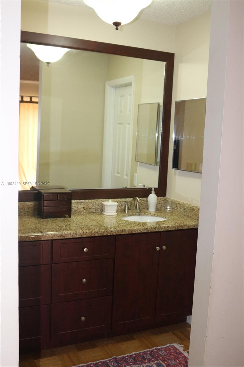 11841 Southwest 94th Street Miami, FL 33186 - Photo 8 of 19 a bathroom with a granite countertop sink and a mirror