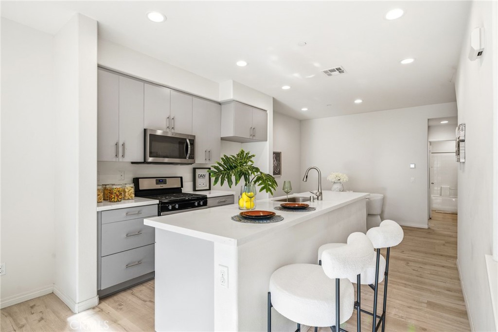 11130 Legion Loop, Unit 105 El Monte, CA 91731 - Photo 8 of 49 a kitchen with a sink a stove and chairs