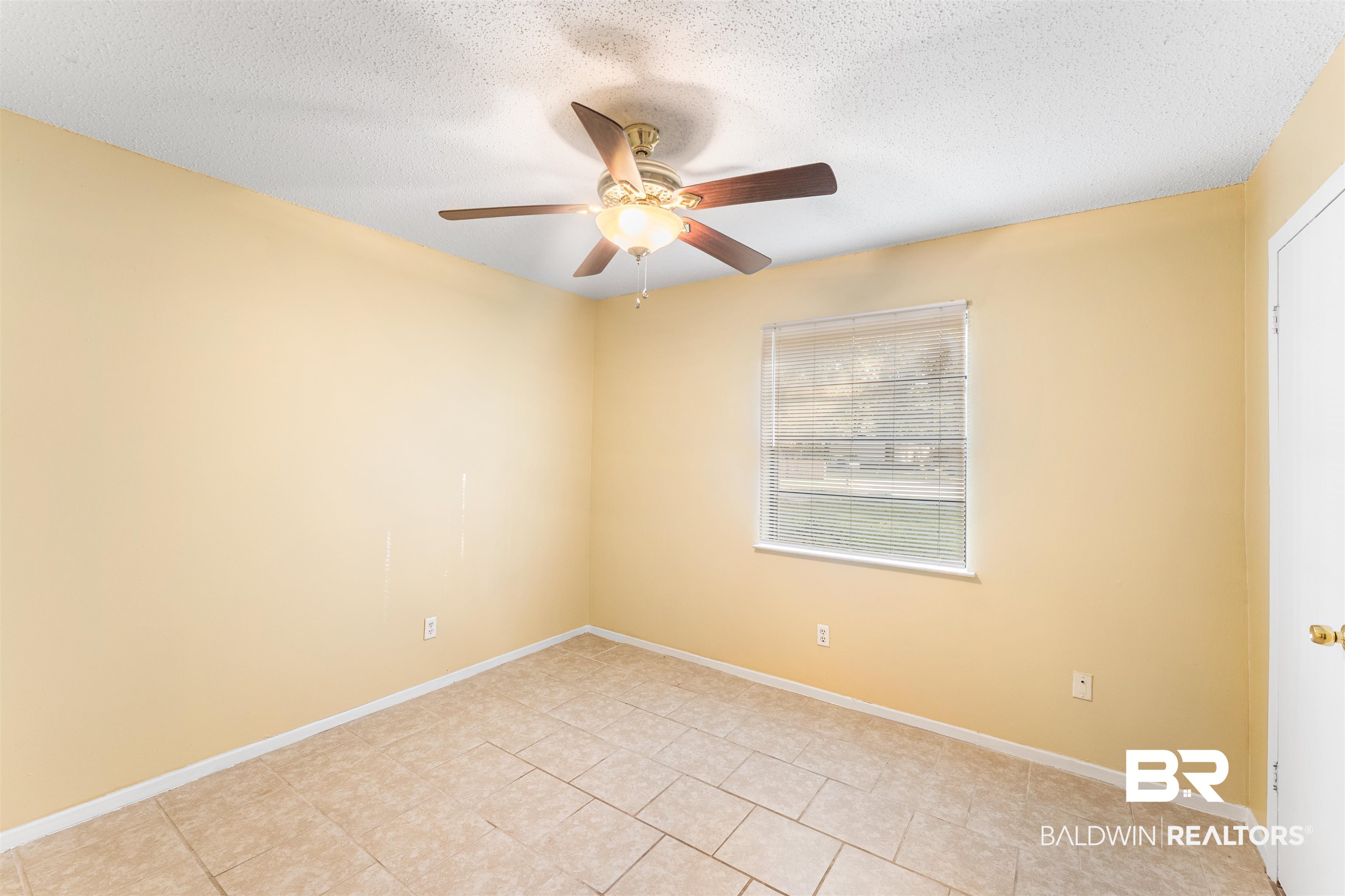 5551 Springer Court Theodore, AL 36582 - Photo 28 of 37 Spare room with a textured ceiling, a ceiling fan, and light tile patterned floors