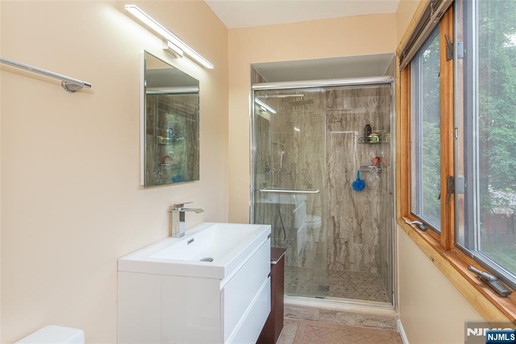 12 Abbott Road Wayne, NJ 07470 - Photo 33 of 49 a bathroom with a shower sink and mirror