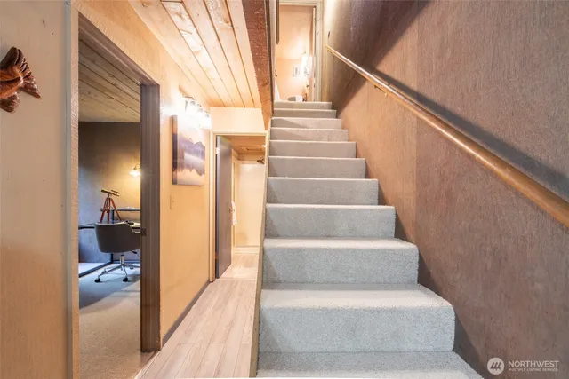 a view of a hallway with wooden floor and staircase