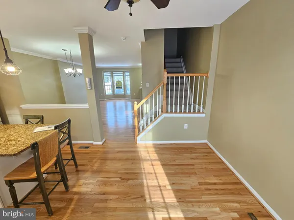 a view of a hallway with wooden floor and a chandelier
