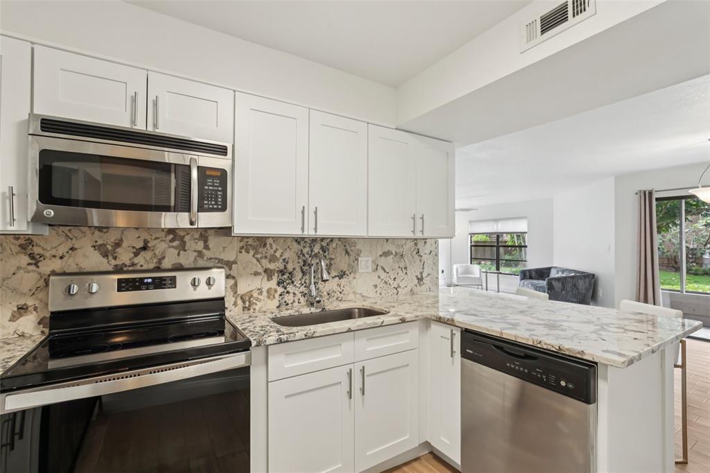 2407 Cypress Pond Road, Unit 2407 Palm Harbor, FL 34683 - Photo 11 of 28 a kitchen with granite countertop white cabinets and appliances