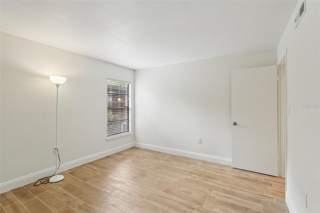 2407 Cypress Pond Road, Unit 2407 Palm Harbor, FL 34683 - Photo 17 of 28 a view of an empty room with wooden floor and a window