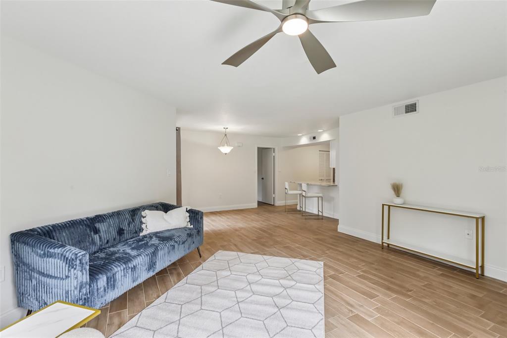 2407 Cypress Pond Road, Unit 2407 Palm Harbor, FL 34683 - Photo 6 of 28 a living room with furniture and a ceiling fan
