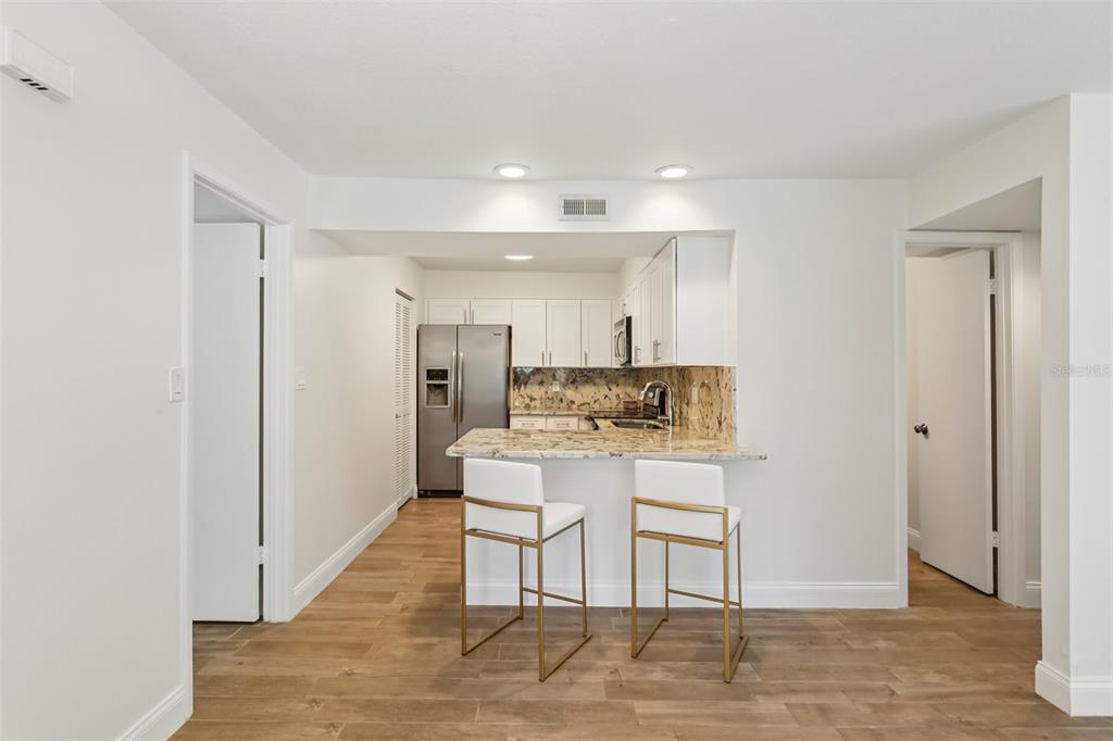 2407 Cypress Pond Road, Unit 2407 Palm Harbor, FL 34683 - Photo 8 of 28 a view of kitchen with white furniture refrigerator and wooden floor