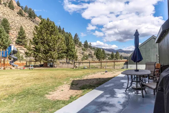 a view of swimming pool with lawn chairs and plants