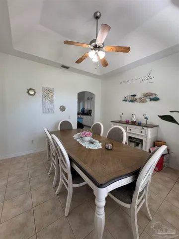a view of a dining room with furniture and a chandelier fan