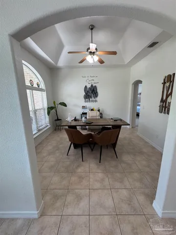 a dining room with chandelier and wooden floor