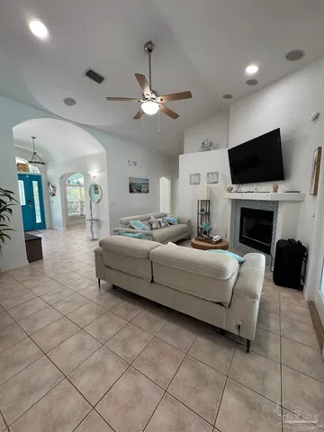 a living room with furniture a flat screen tv and a fireplace