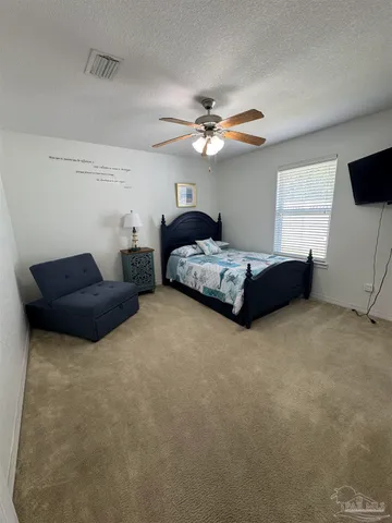 a bedroom with a bed and ceiling fan