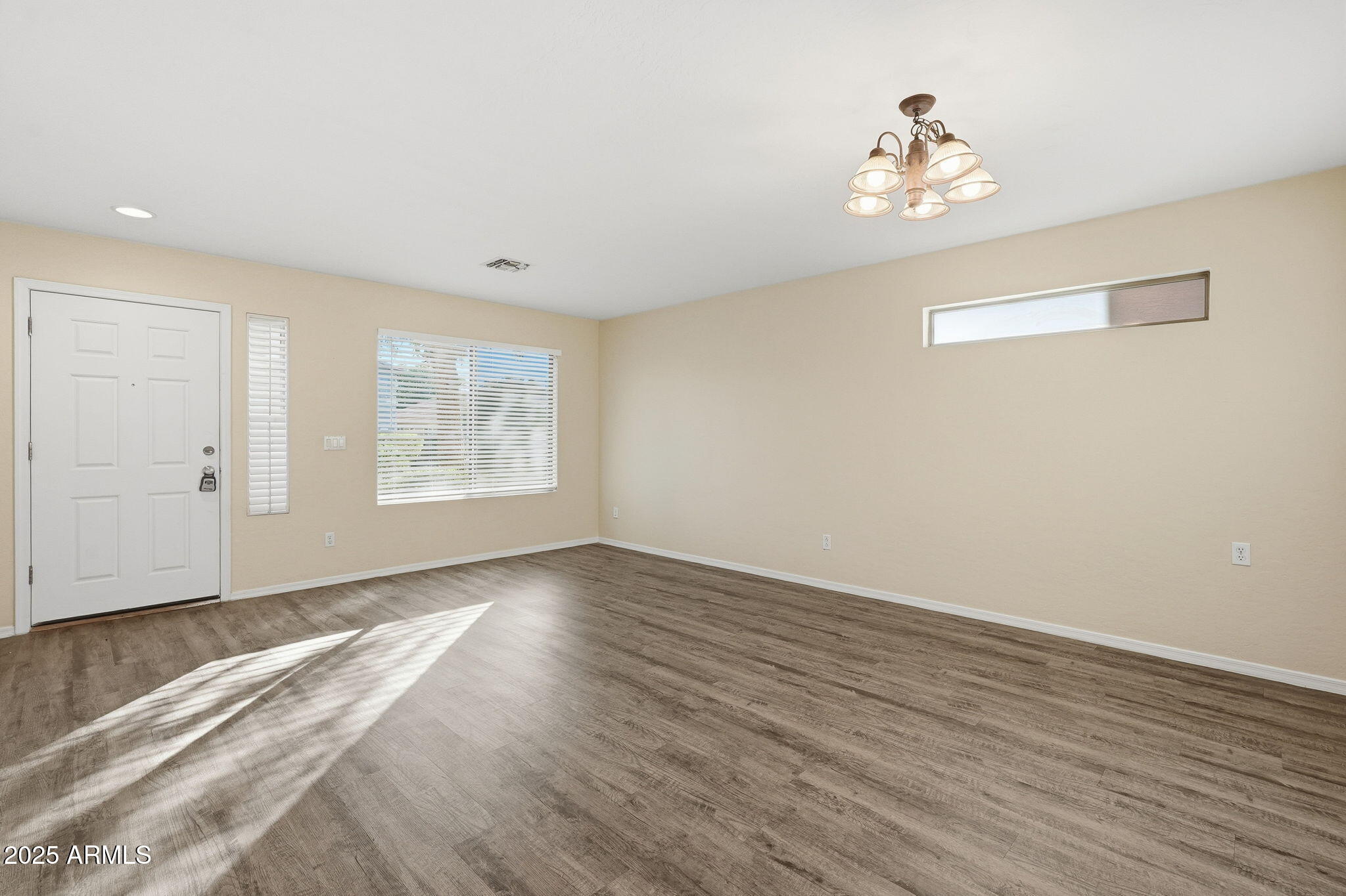 6782 West Rowel Road Peoria, AZ 85383 - Photo 15 of 42 a view of an empty room with wooden floor and a window