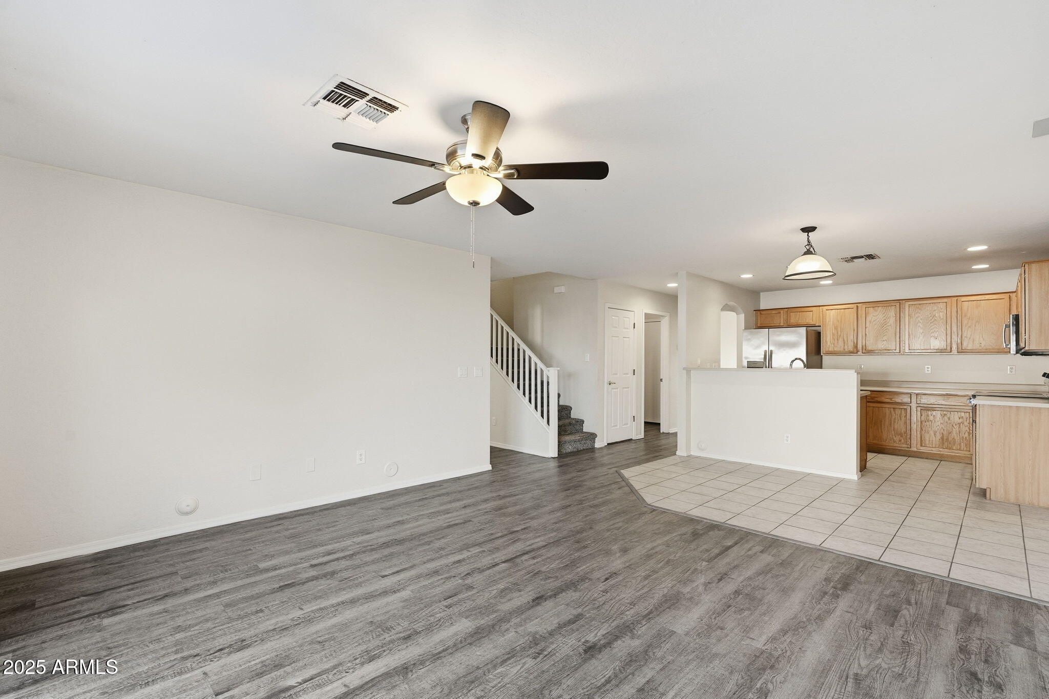6782 West Rowel Road Peoria, AZ 85383 - Photo 3 of 42 a view of a kitchen with wooden floor and a ceiling fan
